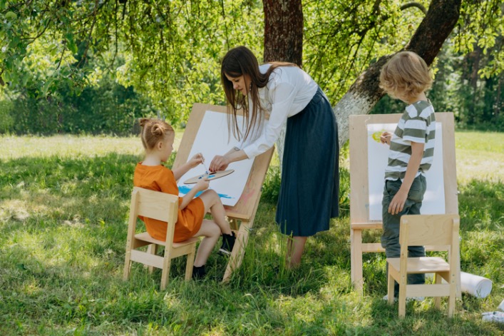 An experienced acrylic painting coach guiding students through a vibrant canvas creation, sparking creativity and artistic expression.